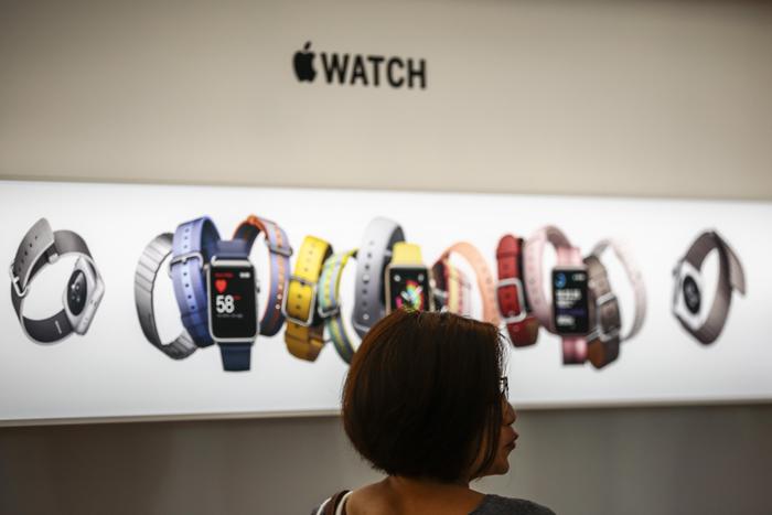 epa06218679 A woman pictured against an Apple watch display at the Apple Orchard store in Singapore, 22 September 2017. The iPhone 8, iPhone 8 Plus and iPhone X were announced by tech giant Apple as the latest iterations of their iconic mobile devices. EPA/WALLACE WOON